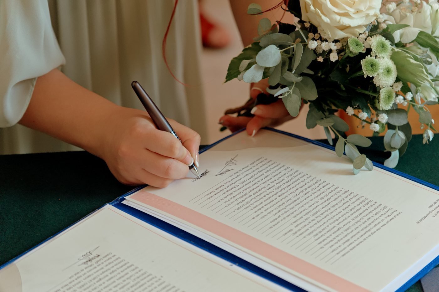 Signature du registre de mariage près d’un bouquet